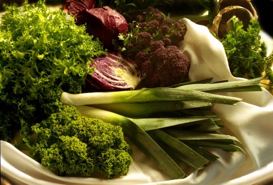 still life of salad leaves, kale, sprouting broccoli, leeks and red cabbage