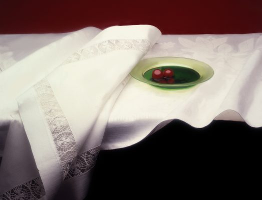 3 two cherries in a green bowl on a white cloth